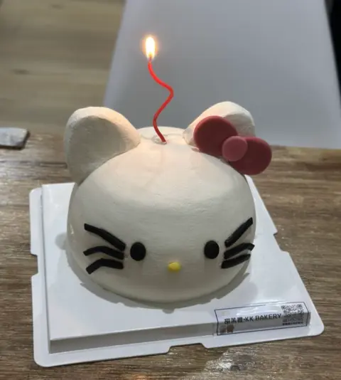 #413 Hello Kitty inspired birthday cake with white face, pink bow and candle by KK Bakery in Rosemead