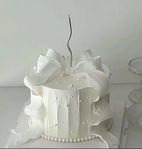 #428 elegant white cake wrapped with large sculpted ribbon bow and pearl details by KK Bakery in Rosemead
