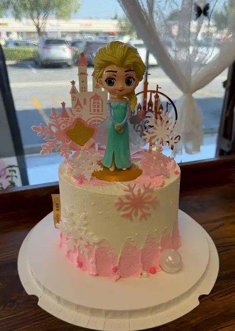 #521 Frozen inspired birthday cake with princess topper, snowflakes and pastel pink details by KK Bakery in Rosemead
