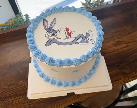 #536 Bugs Bunny inspired birthday cake with blue piped border and character image by KK Bakery in Rosemead