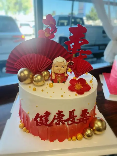 #562 Chinese longevity cake with red fan, elder figurine and gold pearl decorations by KK Bakery in Rosemead