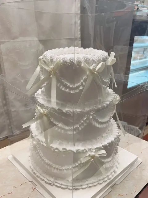 #573 elegant tiered white cake with draped pearl chains and piped borders by KK Bakery in Rosemead