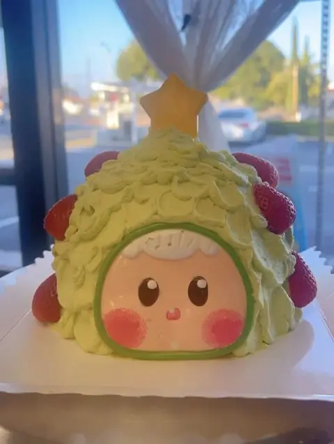 #577 cute Christmas tree character cake with green frosting, star and red ornaments by KK Bakery in Rosemead