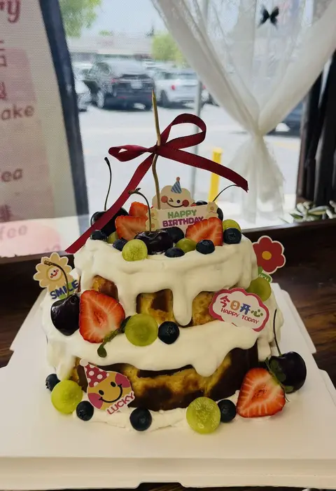 #587 white drip cake topped with strawberries, blueberries and assorted fresh fruit by KK Bakery in Rosemead