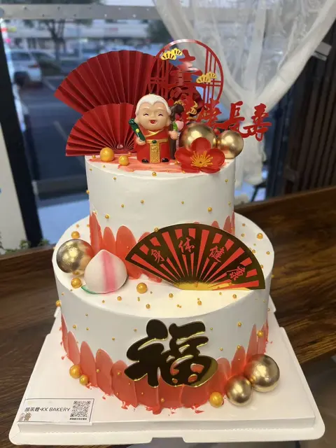 #589 two tier Chinese prosperity cake with red fans, peach and gold blessing decorations by KK Bakery in Rosemead