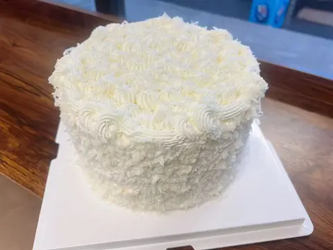 #631 white cream cake covered with shredded coconut and piped buttercream by KK Bakery in Rosemead