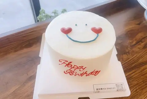 #635 minimalist white birthday cake with a smiling face and red heart cheeks by KK Bakery in Rosemead