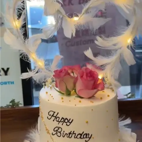 #636 white birthday cake with illuminated feather heart topper, pink roses and gold pearl details by KK Bakery in Rosemead