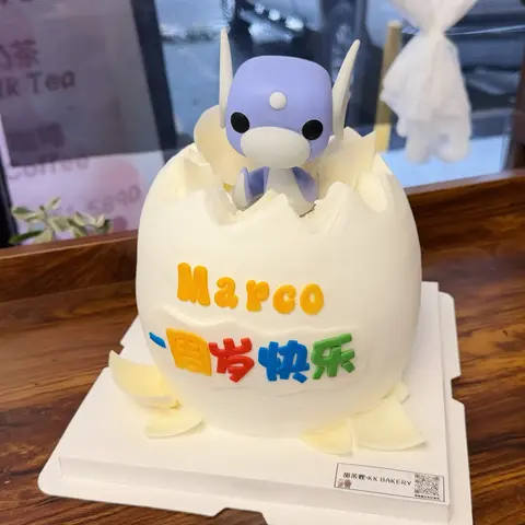 #639 dragon egg inspired birthday cake with a purple baby dragon figure and cracked white shell by KK Bakery in Rosemead