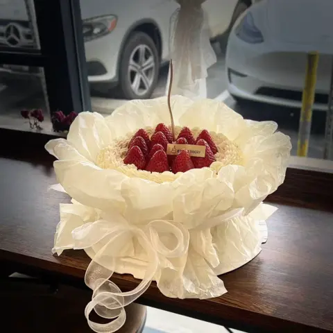 #642 strawberry bouquet cake wrapped in white paper with ribbon and fresh strawberries by KK Bakery in Rosemead