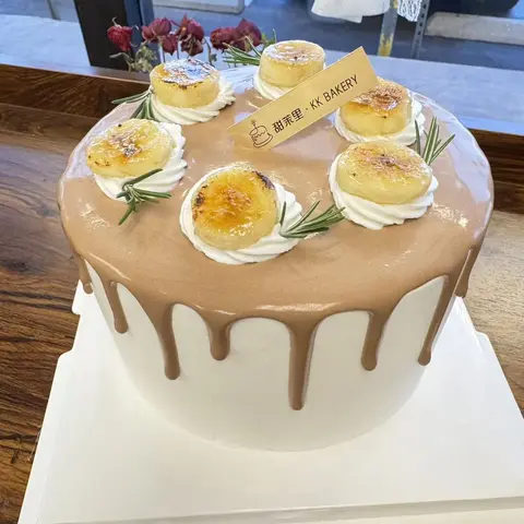 #643 white cake with caramel drip, mini crème brûlée toppings and rosemary accents by KK Bakery in Rosemead