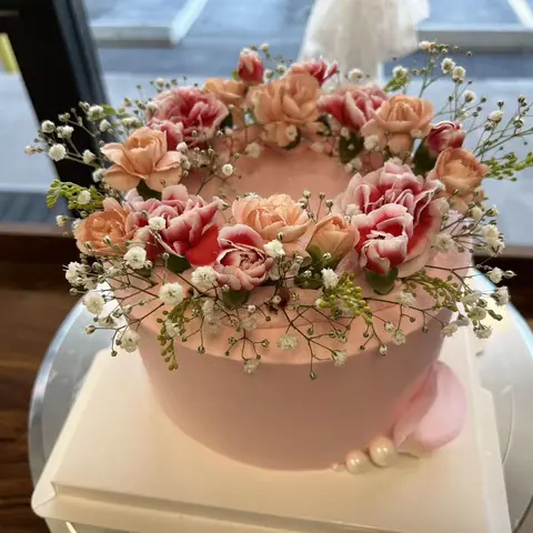 #646 pink celebration cake with a wreath of fresh pink roses and baby's breath flowers by KK Bakery in Rosemead